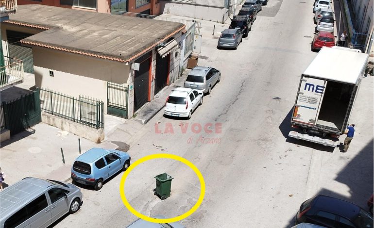 Via Ferrara, un cassonetto per segnalare una buca pericolosa