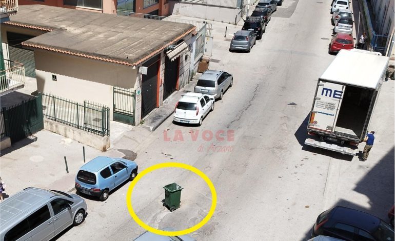 Via Ferrara, un cassonetto per segnalare una buca pericolosa